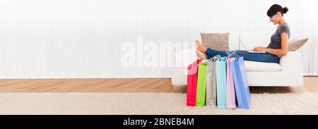 Bonne femme Shopper Shopping en ligne dans la boutique Banque D'Images
