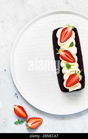 Brownie au chocolat avec crème à la vanille aérée et fraises fraîches. Gâteau au chocolat avec crème et baies fraîches. Thé dessert Banque D'Images