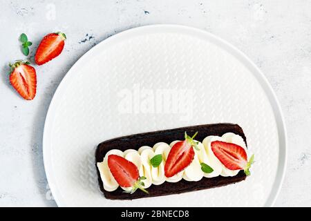 Brownie au chocolat avec crème à la vanille aérée et fraises fraîches. Gâteau au chocolat avec crème et baies fraîches. Thé dessert Banque D'Images