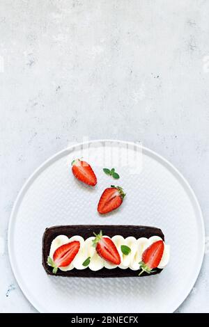 Brownie au chocolat avec crème à la vanille aérée et fraises fraîches. Gâteau au chocolat avec crème et baies fraîches. Thé dessert Banque D'Images