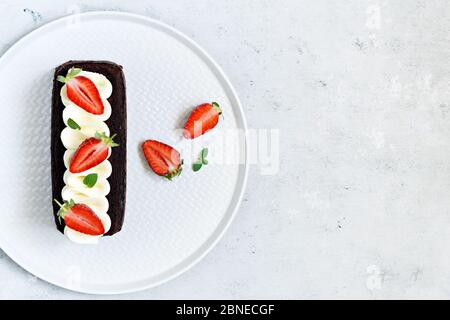 Brownie au chocolat avec crème à la vanille aérée et fraises fraîches. Gâteau au chocolat avec crème et baies fraîches. Thé dessert Banque D'Images