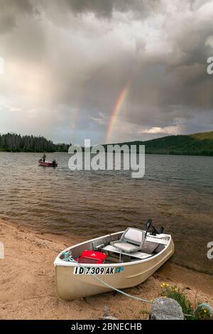 Doug Anderson pêche sur le lac Stanley pendant la pluie, avec Rainbow, Stanley Lake National Recreation Area, Idaho, États-Unis. Juillet 2015. Modèle libéré. Banque D'Images