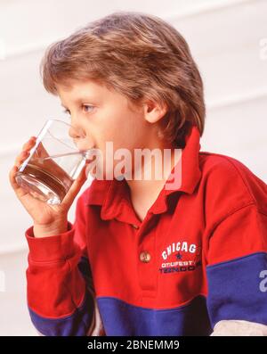Jeune fille buvant un verre d'eau, Winkfield, Berkshire, Angleterre, Royaume-Uni Banque D'Images