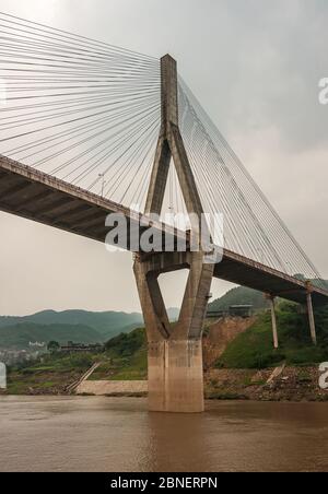 Huangqikou, Chongqing, Chine - 8 mai 2010 : fleuve Yangtze. 1 des 2 pylônes en forme de losange du pont de suspension G319 avec câbles. Eau brune et vert h Banque D'Images