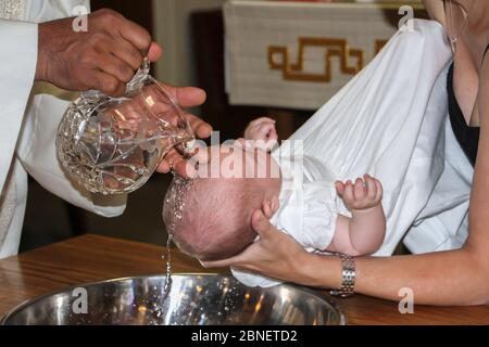Enfant recevant de l'eau de baptême Banque D'Images