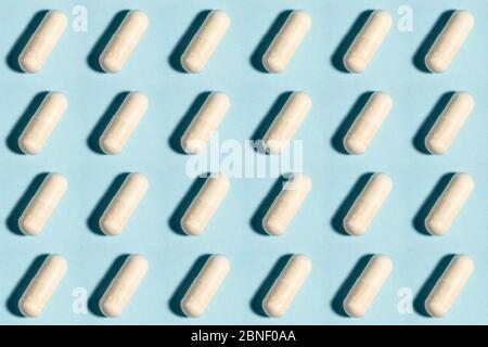 Comprimé médical sans couture, modèle de capsule de médecine pharmaceutique. Analgésique, vitamine, antibiotique, probiotique sur fond bleu. Concept médical. Scienc Banque D'Images