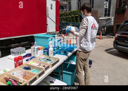 New York, États-Unis. 14 mai 2020. Tommy Heller, membre du personnel, prépare des articles de toilette à la remorque médecins sans frontières/médecins sans frontières pour que les sans-abri prennent une douche chaude et se rasent sur le parking de l'église St John The Baptist RC pendant la pandémie COVID-19. Cette remorque de douche mobile permet de nettoyer jusqu'à 50 personnes par jour. L'organisation prévoit de mettre en place une autre remorque dans les prochains jours pour pouvoir servir plus de personnes. Credit: Pacific Press Agency/Alay Live News Banque D'Images