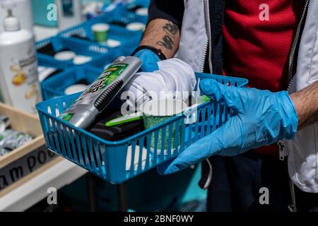 New York, États-Unis. 14 mai 2020. Luis Melendez, membre du personnel, présente un plateau individuel avec des nécessités à médecins sans frontières/remorque médecins sans frontières pour les sans-abri à prendre une douche chaude et se raser sur le parking de l'église St John the Baptist RC pendant la pandémie COVID-19. Cette remorque de douche mobile permet de nettoyer jusqu'à 50 personnes par jour. L'organisation prévoit de mettre en place une autre remorque dans les prochains jours pour pouvoir servir plus de personnes. Credit: Pacific Press Agency/Alay Live News Banque D'Images