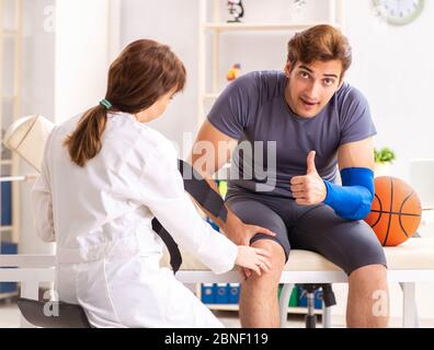 Le beau joueur de basket-ball féminin en visite médecin traumatologist Banque D'Images
