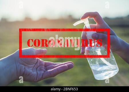 Signe du virus Corona et bouteille en plastique blanc transparent de liquide antibactérien désinfectant dans la main qui coule dans l'autre main avec un fond clair Banque D'Images