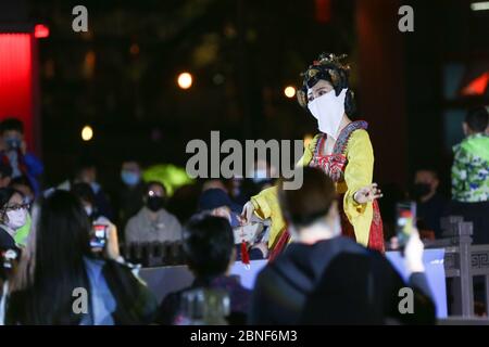 La Tumbler Girl, danseuse d'une attraction touristique locale appelée Grand Tang Dynasty Ever Bright City, se produit pour les touristes avec masque facial sur, Xi'an ci Banque D'Images