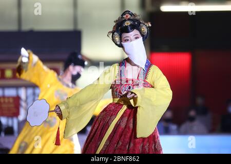 La Tumbler Girl, danseuse d'une attraction touristique locale appelée Grand Tang Dynasty Ever Bright City, se produit pour les touristes avec masque facial sur, Xi'an ci Banque D'Images