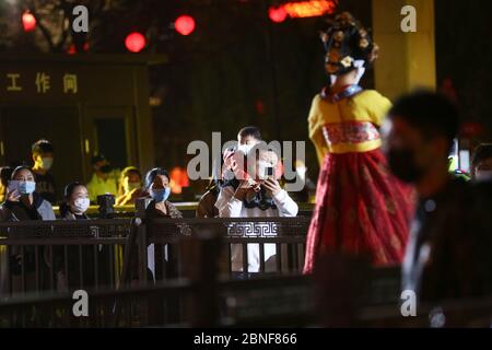 La Tumbler Girl, danseuse d'une attraction touristique locale appelée Grand Tang Dynasty Ever Bright City, se produit pour les touristes avec masque facial sur, Xi'an ci Banque D'Images