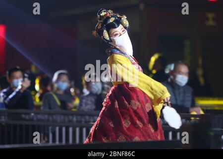 La Tumbler Girl, danseuse d'une attraction touristique locale appelée Grand Tang Dynasty Ever Bright City, se produit pour les touristes avec masque facial sur, Xi'an ci Banque D'Images