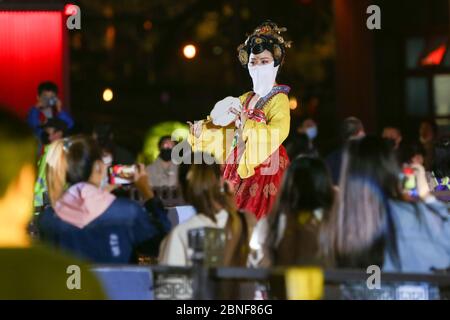 La Tumbler Girl, danseuse d'une attraction touristique locale appelée Grand Tang Dynasty Ever Bright City, se produit pour les touristes avec masque facial sur, Xi'an ci Banque D'Images