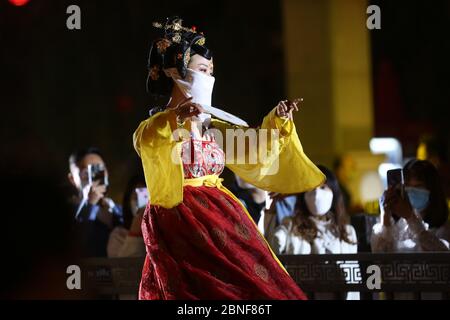 La Tumbler Girl, danseuse d'une attraction touristique locale appelée Grand Tang Dynasty Ever Bright City, se produit pour les touristes avec masque facial sur, Xi'an ci Banque D'Images