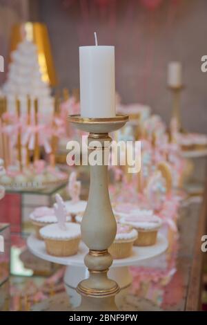 Festival, dîner, vacances, nouvel an . Bar Candy rose . Porte-bougie en laiton . Bougie isolée sur l'arrière-plan flou. Bougie pour dîner de nuit, Banque D'Images