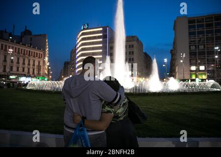 Athènes, Grèce. 14 mai 2020. Un couple se hante à la place Omonia récemment rénovée, un monument historique à Athènes, Grèce, le 14 mai 2020. Le nouveau visage de la place Omonia, doté d'une grande fontaine illuminée, a été dévoilé jeudi par le maire d'Athènes, Kostas Bakoyannis. Crédit: Lefteris Partsalis/Xinhua/Alay Live News Banque D'Images