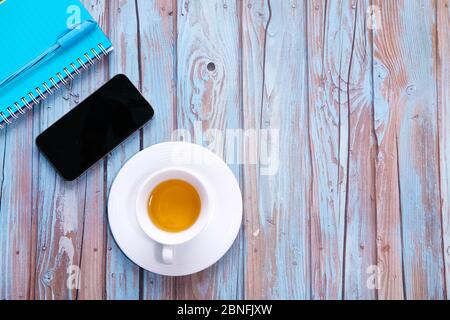 Vue de dessus du smartphone avec écran vide et bloc-notes sur fond en bois Banque D'Images