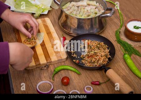 Femme préparant à la main mahtiy - repas traditionnel égyptien : choux farcis rouleaux Banque D'Images