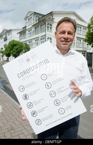 Binz, Allemagne. 13 mai 2020. L'hôtelier Gunter Preusker se trouve en face de son hôtel et montre un signe pour le bon comportement à l'époque de Corona. Après la détente dans la crise de Corona, l'ouverture des premiers hôtels de Mecklembourg-Poméranie-Occidentale est imminente. Les hôtels peuvent ouvrir à partir de 18.05.2020. Il y a la règle des 60 pour cent. Credit: Stefan Sauer/dpa/Alay Live News Banque D'Images