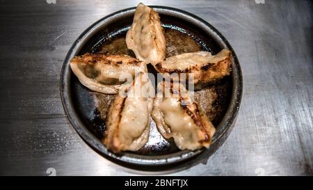 Boulettes frites dans un restaurant. Guotie est une cuisine japonaise traditionnelle. Portions de délicieux gyoza servies sur la table en métal. Banque D'Images