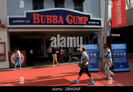 Orlando, États-Unis. 14 mai 2020. Les clients attendent d'entrer au restaurant Bubba Gump Shrimp Co. De l'Universal Orlando CityWalk, alors que des sections du quartier des divertissements et des magasins ont ouvert leurs portes aujourd'hui pour une durée limitée pour la première fois depuis la fermeture de Universal Orlando le 15 mars 2020 en raison de la pandémie du coronavirus. Outre les revêtements de surface, des contrôles de température sont également nécessaires. Les parcs thématiques Universal seront fermés jusqu'au moins en mai 31. Crédit : SOPA Images Limited/Alamy Live News Banque D'Images