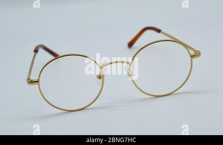 Paire de lunettes ou de lunettes à bord doré sur fond blanc dans un cliché de studio Banque D'Images