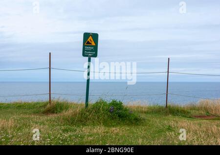 Attention ! Un panneau d’avertissement d’érosion de la falaise est affiché sur la rive nord de l’Île-du-Prince-Édouard. Golfe du Saint-Laurent, Océan Atlantique. Parc national de l'Î.-P.-É., Canada Banque D'Images