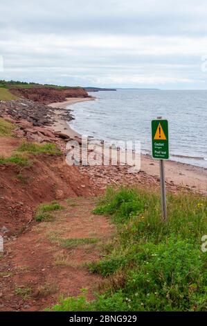 Attention ! Un panneau d’avertissement d’érosion de la falaise est affiché sur la rive nord de l’Île-du-Prince-Édouard. Golfe du Saint-Laurent, Océan Atlantique. Parc national de l'Î.-P.-É., Canada Banque D'Images