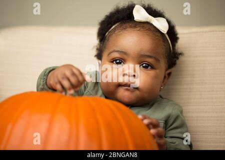 African American cute little girl holding a pumpkin. Banque D'Images