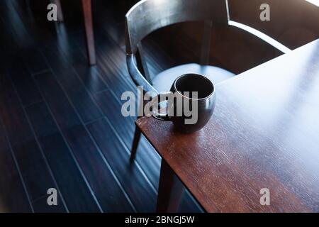 Une tasse de café assis sur une table en bois Banque D'Images