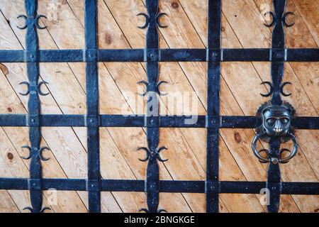 Portes en bois avec treillis forgé noir avec poignée sous forme de tête de lion Banque D'Images
