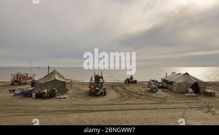 Drague à l'or et des tentes sur la plage, péninsule Sewards, Nome, Alaska, USA, septembre. Banque D'Images