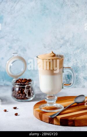 Dalgona Coffee sur fond de Ligrht. Café fouetté crémeux tendance. Boisson d'été froide coréenne. Banque D'Images