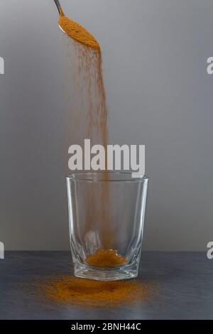 Café tombant de la cuillère à vider le verre sur le bureau en pierre Banque D'Images