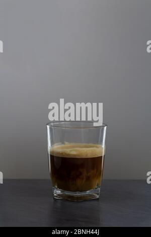 Préparation de lait dans le café, petit verre sur le bureau en pierre Banque D'Images