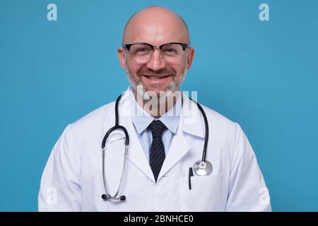 Sourire mature médecin en manteau blanc et stéthoscope Banque D'Images