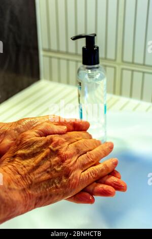 Femme se nettoyant les mains avec du gel hydroalcoolique Banque D'Images