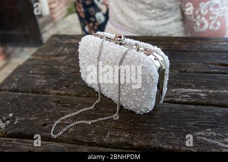 Une cérémonie de mariage extravagante a lieu dans un hôtel de Surrey, en Angleterre. Un sac à main élégant aux brides étincelantes se place sur une table. Banque D'Images