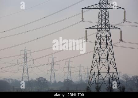 Lignes électriques haute tension et pylônes dans la campagne, Gloucestershire, Royaume-Uni. Mars 2015. Banque D'Images