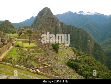Vue panoramique de la Citadelle antique de Machu Picchu en début de matinée avec peu de visiteurs, région de Cuzco, Pérou, Amérique du Sud Banque D'Images