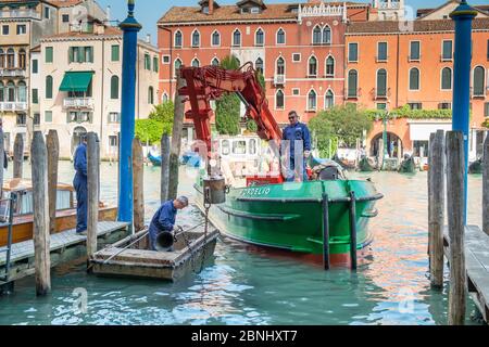 Barge d'entretien réparant les postes d'amarrage sur le Grand Canal, Venise, Italie. Banque D'Images