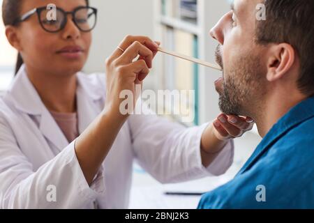 Femme médecin examinant la gorge du patient pendant sa visite à l'hôpital Banque D'Images