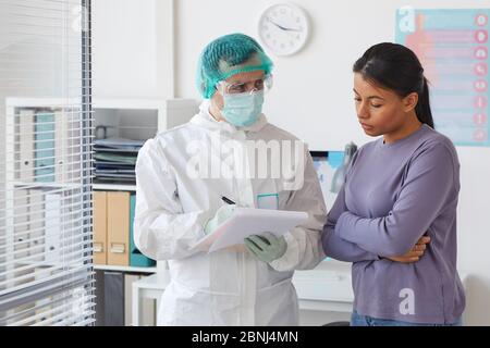 Jeune femme écoutant la recommandation du médecin pendant qu'il lui prescrira un médicament à l'hôpital Banque D'Images