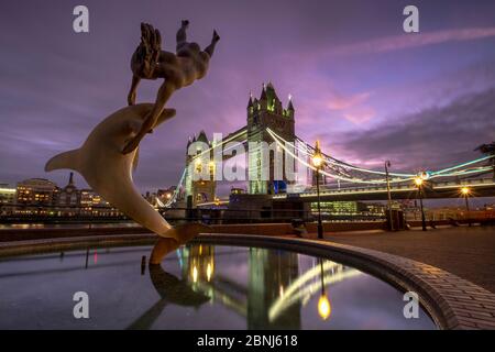 Tower Bridge avec la statue de fille et de dauphin à St. Katherines Dock la nuit, Londres, Angleterre, Royaume-Uni, Europe Banque D'Images