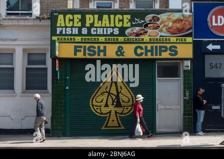 West Norwood, Royaume-Uni. 15 mai 2020. Une dame passe devant un marché fermé de poissons et de jetons à emporter tout en portant un masque facial et des distances sociales dans le sud de Londres. (Photo de Sam Mellish / Alamy Live News) Banque D'Images