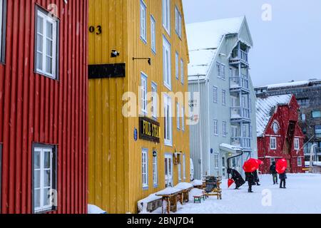 Touristes, bâtiments historiques en bois colorés, neige épaisse en hiver, Tromso, Troms og Finnmark, cercle arctique, Norvège du Nord, Scandinavie, Europe Banque D'Images