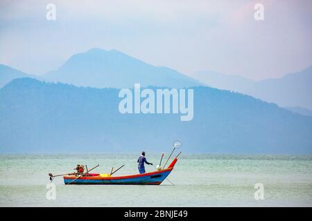 Pêcheur sur petit bateau, détroit de Malacca avec île thaïlandaise de Ko Tarutao de la plage de la baie de Datai (Pantai Teluk Datai), mer d'Andaman, Malaisie, sud-est Banque D'Images