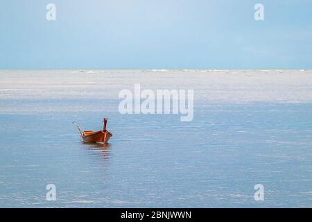 Petit bateau isolé avec réflexion flottant sur la mer Banque D'Images